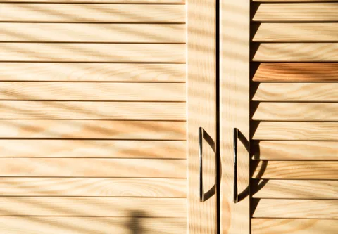 Puertas de madera tipo celosía con manijas negras